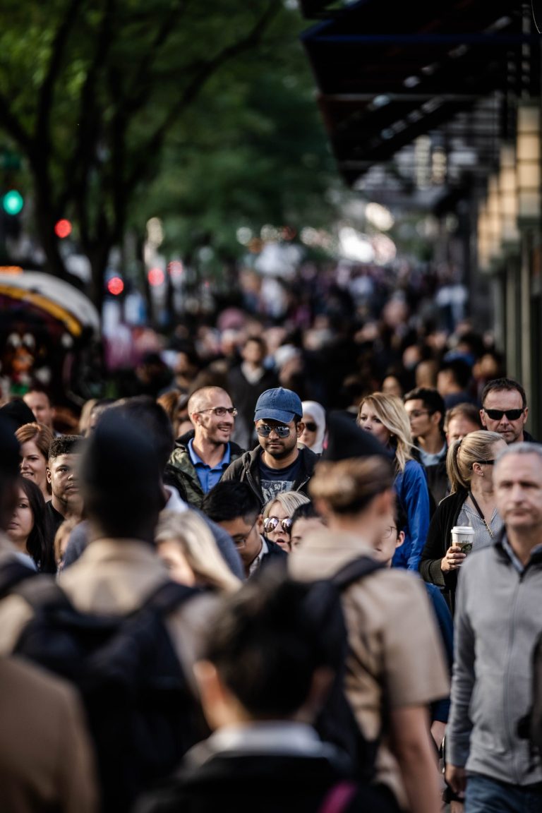 A crowded city street seen from a surveillance position, one figure tracked among many